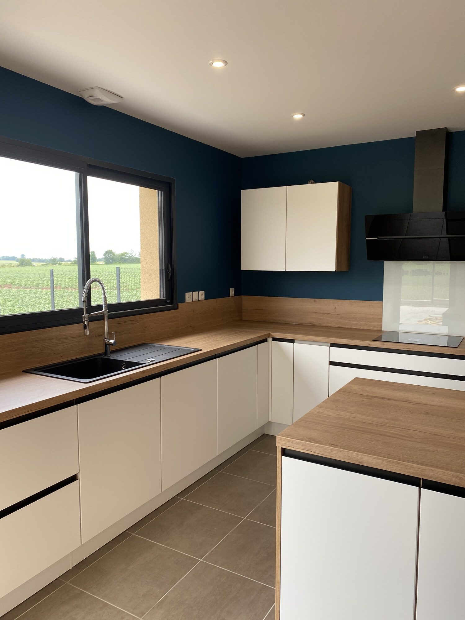 Cuisiniste Rouen, vue aérienne de cuisine moderne avec évier noir et mur bleu