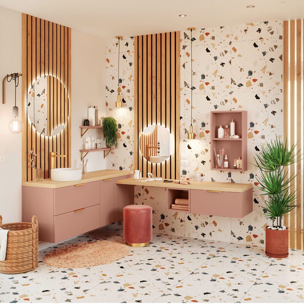 Meuble de salle de bains Osmose nude abricot en L flottant, plan bois, vasque à poser, miroirs ronds et terrazzo — ambiance contemporaine et chaleureuse.